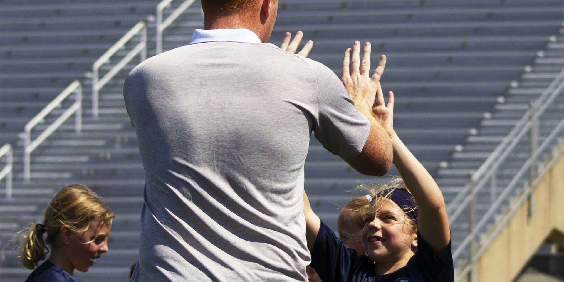 Coach giving children a double high five Coach giving children a double high five
