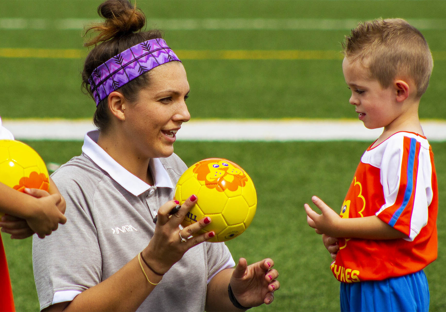 TinyTykes coach talking to a young player TinyTykes coach talking to a young player